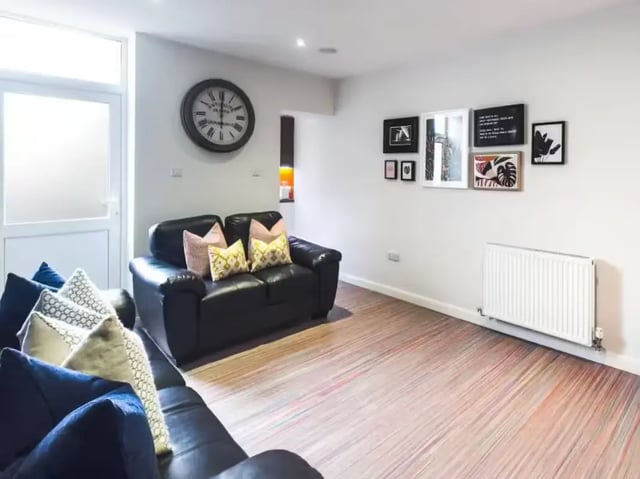 Black sofas with patterned pillows living room at 15 Carlton Road in Stoke-On-Trent Student Accommodation