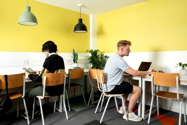 Students working at desks with laptops and magazines study area at Beech House in Oxford Student Accommodation