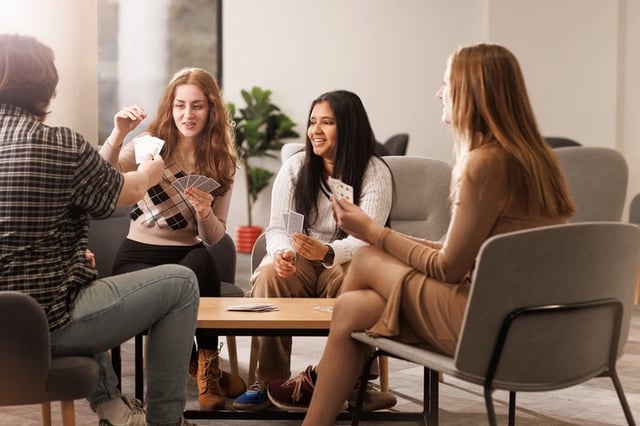 Students playing cards at a table living room at Chaucer House in Portsmouth Student Accommodation