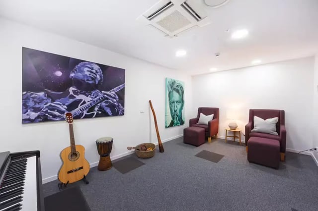 Piano guitar drums art chairs lounge area at Scape Regent in Brisbane Student Accommodation
