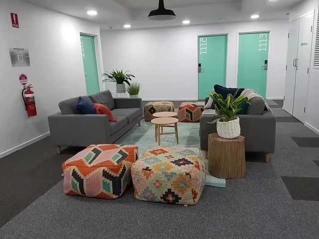 Sofas poufs tables and plants communal living area at Scape Regent in Brisbane Student Accommodation