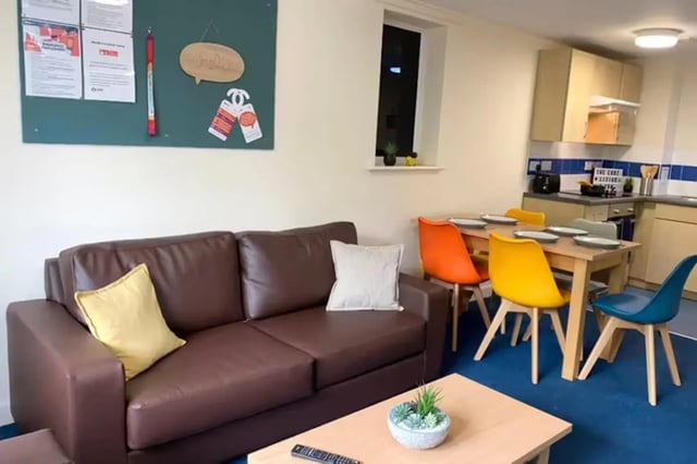 Brown sofa dining table colorful chairs kitchen living room at The Cube - Loughborough in Loughborough Student Accommodation