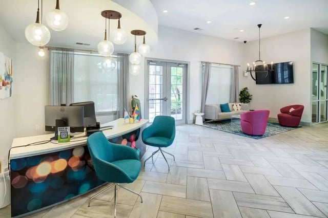 Reception desk with computers and seating area living room at Orion on Orpington in Orlando Student Accommodation