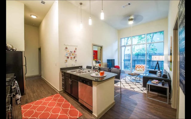 Kitchen with island and living area Image at The Lorimer in Denton Student Accommodation