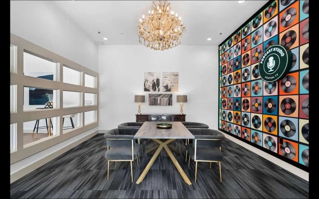 Table with chairs and vinyl record wall living room at The Lorimer in Denton Student Accommodation
