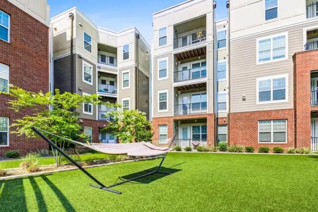 Hammock on green lawn with apartments exterior at Quantum On West Call in Tallahassee Student Accommodation