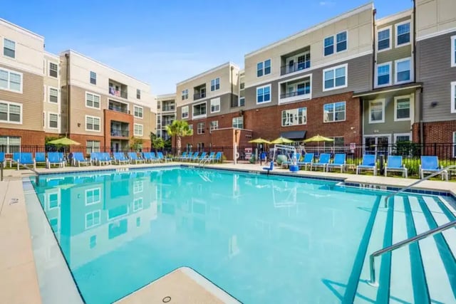 Apartment buildings surrounding a blue swimming pool playing area at Quantum On West Call in Tallahassee Student Accommodation