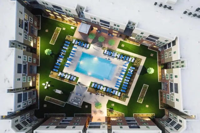 Pool lounge chairs umbrellas green lawn exterior at Quantum On West Call in Tallahassee Student Accommodation