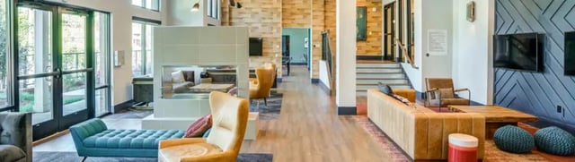 Modern lounge with sofas fireplace and TVs living room at Signature 1505 (Theory) in Raleigh Student Accommodation