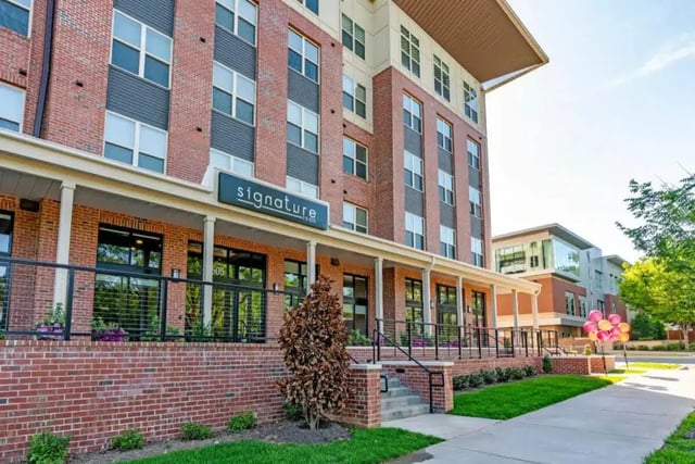 Brick building with large windows and signage exterior at Signature 1505 (Theory) in Raleigh Student Accommodation