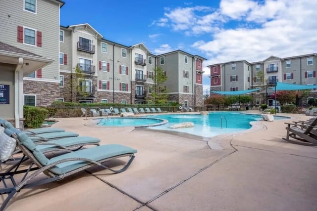 Pool lounge chairs by swimming pool exterior at Arba in San Marcos Student Accommodation