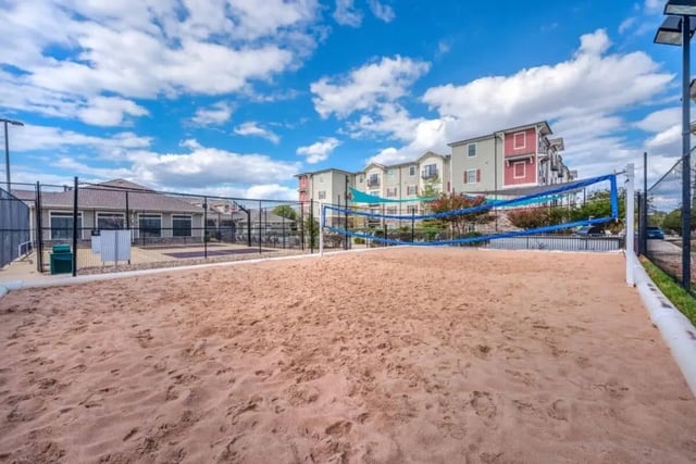 Sand volleyball court with apartment buildings exterior at Arba in San Marcos Student Accommodation
