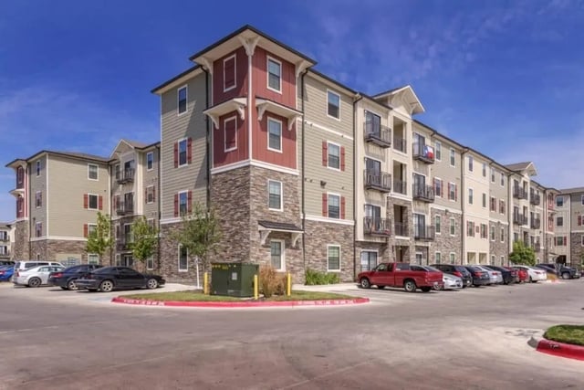 Apartment building exterior with parking lot exterior at Arba in San Marcos Student Accommodation