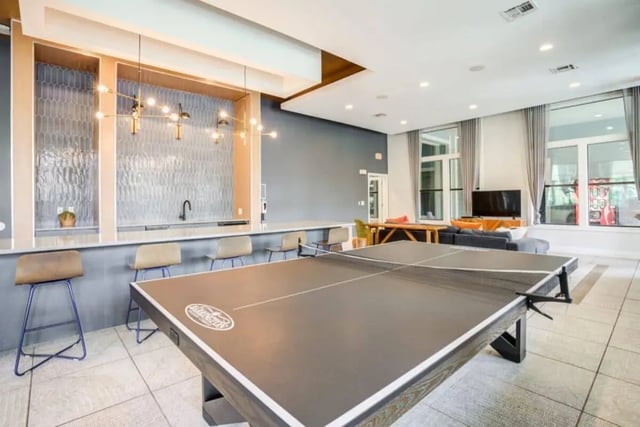 Ping pong table bar stools sofa television lounge area at The Mill at Auburn in Auburn Student Accommodation