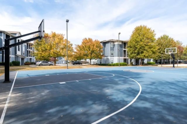 Blue basketball court with buildings and trees exterior at The Mill at Auburn in Auburn Student Accommodation