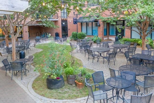 Outdoor patio tables and chairs with greenery courtyard at Courtyard Lofts in Chapel Hill Student Accommodation