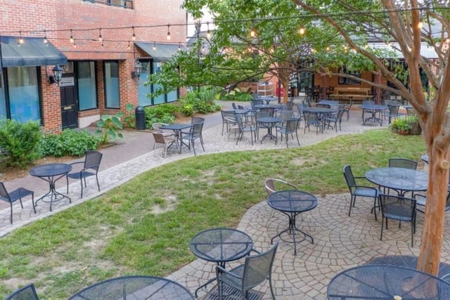 Outdoor tables and chairs with string lights exterior at Courtyard Lofts in Chapel Hill Student Accommodation