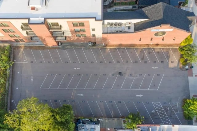 Empty parking lot beside brick buildings exterior at Courtyard Lofts in Chapel Hill Student Accommodation