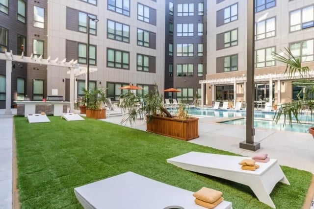 Cornhole games by pool and outdoor kitchen exterior at The Nest At University Center in Rock Hill Student Accommodation