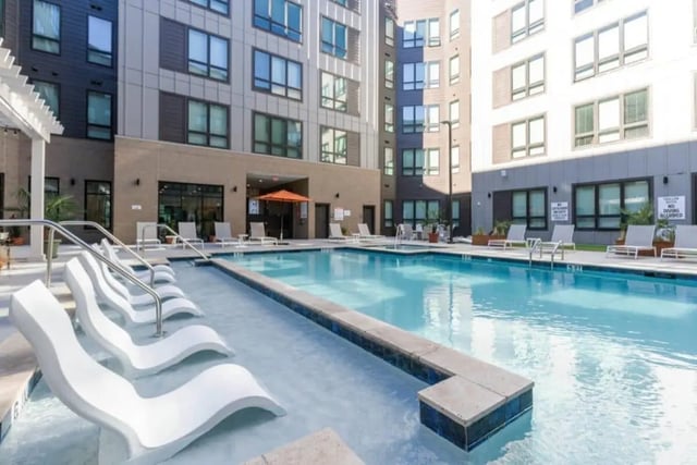 White lounge chairs pool building exterior at The Nest At University Center in Rock Hill Student Accommodation