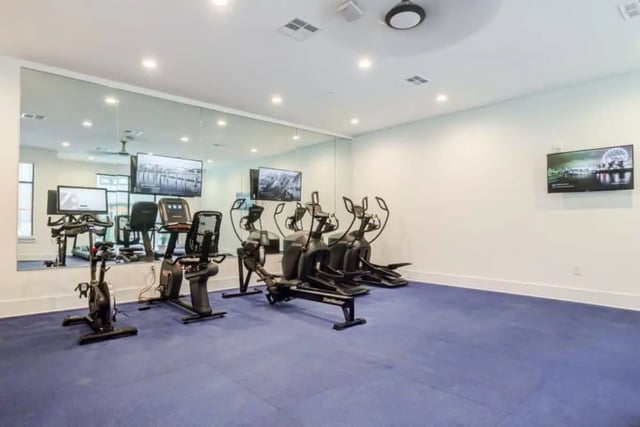 Exercise equipment mirrors and TVs gym at The Nest At University Center in Rock Hill Student Accommodation