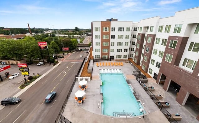 Apartment building with pool lounge chairs and street view exterior at Nova Knoxville in Knoxville Student Accommodation