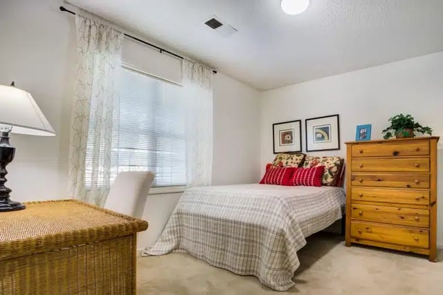 Bed dresser lamp and framed art bedroom at University Woods in Raleigh Student Accommodation