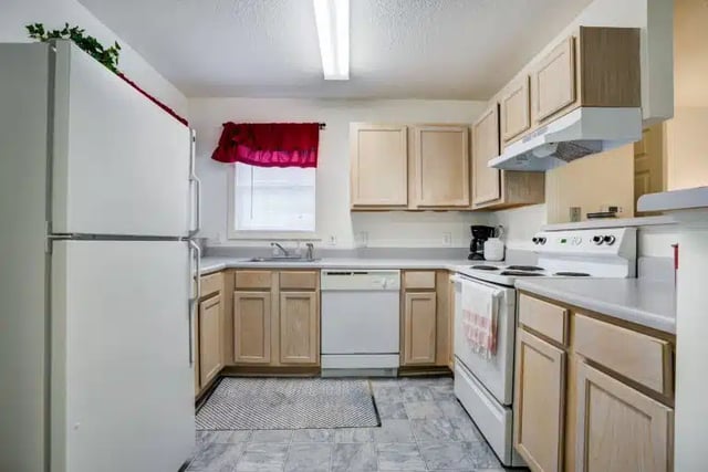 White refrigerator dishwasher stove cabinets kitchen at University Woods in Raleigh Student Accommodation