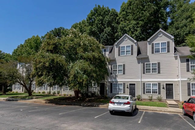 Townhouses with cars in parking lot exterior at Red Wolf Crossing in Raleigh Student Accommodation