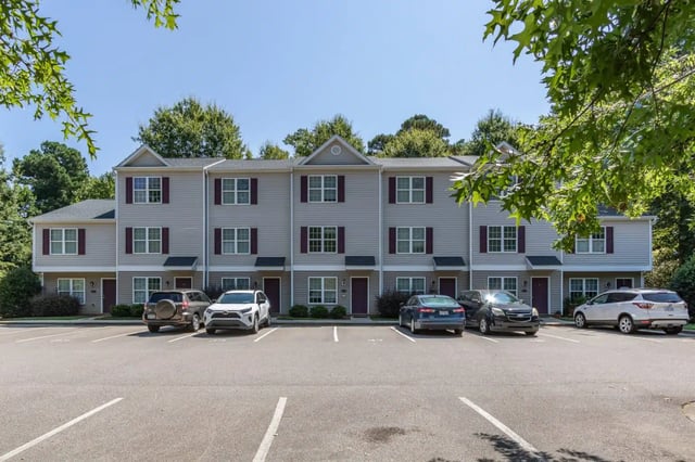 Townhouses with cars and parking lot exterior at Red Wolf Crossing in Raleigh Student Accommodation