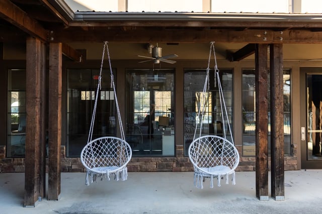 Two white hanging chairs with cushions Outdoor patio area at University Village at 2505 in Raleigh Student Accommodation