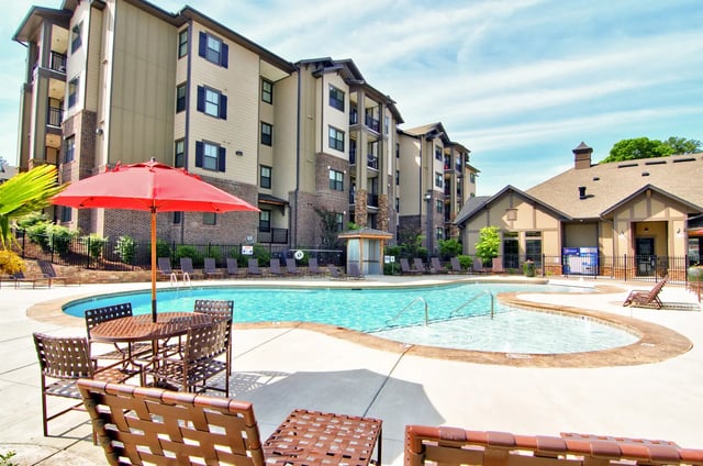 Pool with chairs umbrellas and apartment buildings exterior at University Village at 2505 in Raleigh Student Accommodation