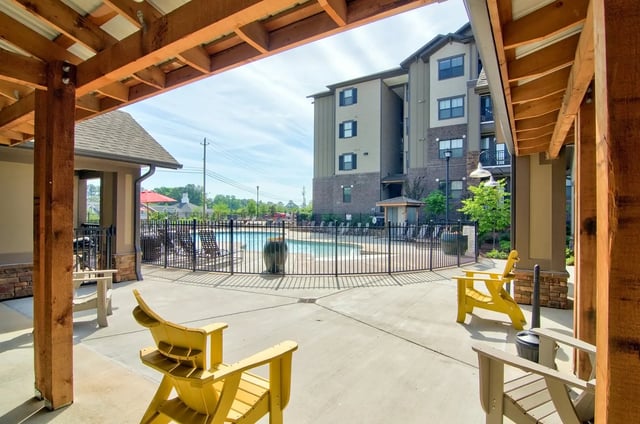 Yellow chairs by pool exterior apartment building at University Village at 2505 in Raleigh Student Accommodation