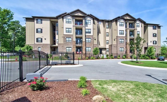 Apartment building with black gate and red flowers exterior at University Village at 2505 in Raleigh Student Accommodation