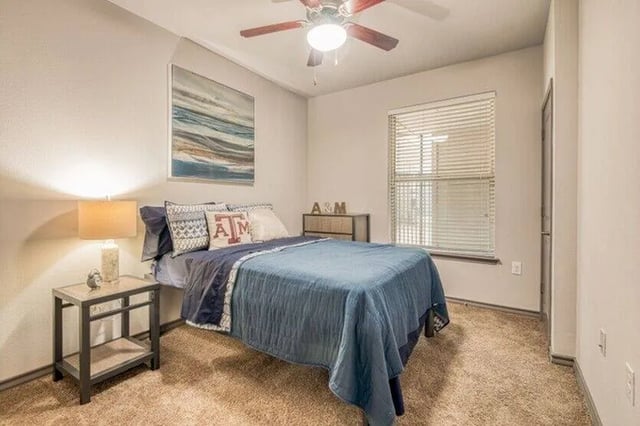 Bed with blue quilt and pillows bedroom at Cherry Street in College Station Student Accommodation