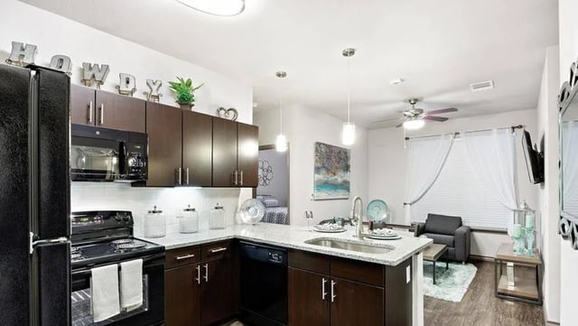 Modern kitchen with stainless steel appliances living area living room at Cherry Street in College Station Student Accommodation