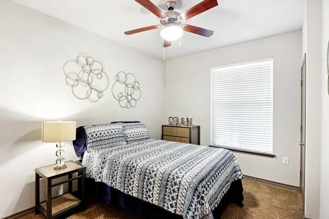 Bed nightstand wall art ceiling fan bedroom at Cherry Street in College Station Student Accommodation