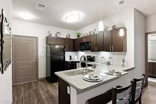 Kitchen with island refrigerator and seating kitchen at Cherry Street in College Station Student Accommodation