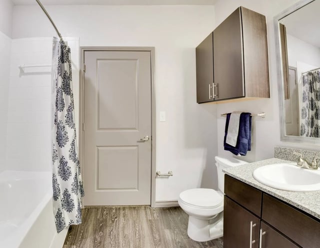 Bathtub toilet vanity sink shower curtain cabinet bathroom at Cherry Street in College Station Student Accommodation