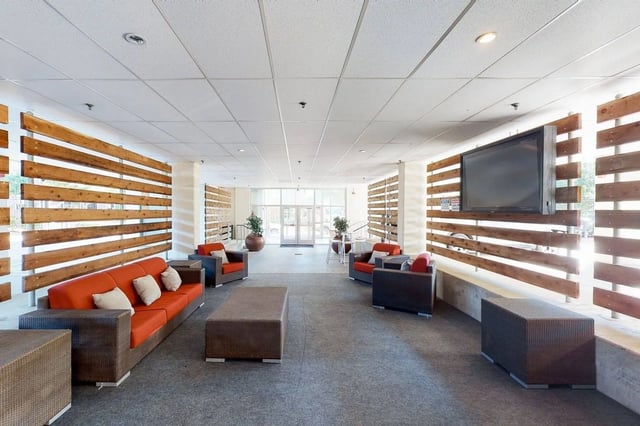 Orange sofas chairs coffee tables and television living room at Cherry Street in College Station Student Accommodation