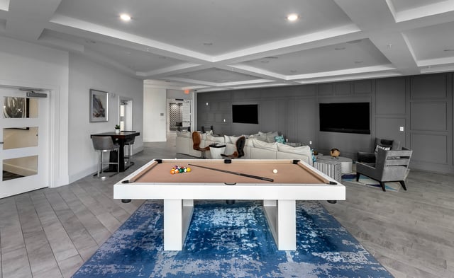 Pool table sofa chairs and TVs living area at Berkeley House in College Station Student Accommodation