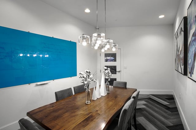 Wooden table with chairs blue board and art. Meeting room. at Berkeley House in College Station Student Accommodation