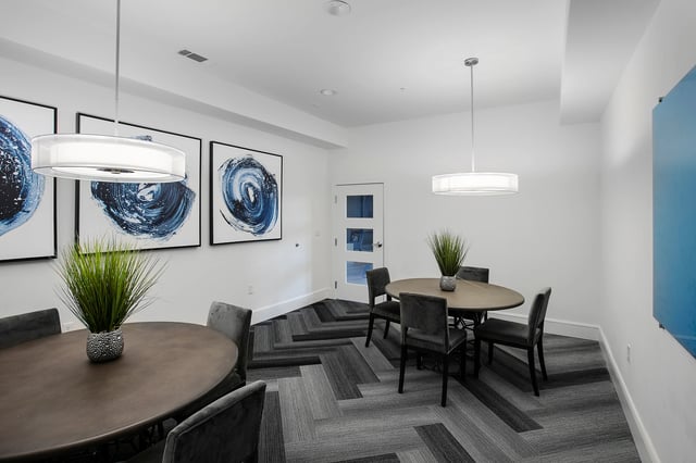 Two round tables plush chairs abstract art common area at Berkeley House in College Station Student Accommodation