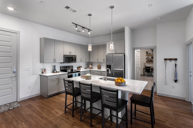 Kitchen with island stainless steel appliances and seating kitchen at Berkeley House in College Station Student Accommodation