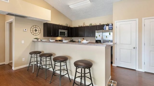 Bar stools and counter with kitchen appliances kitchen at The Hangout in Starkville Student Accommodation