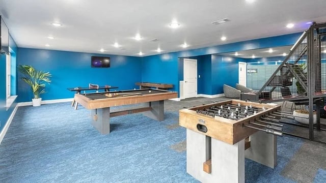 Pool tables foosball table and seating area recreation room at The Hangout in Starkville Student Accommodation
