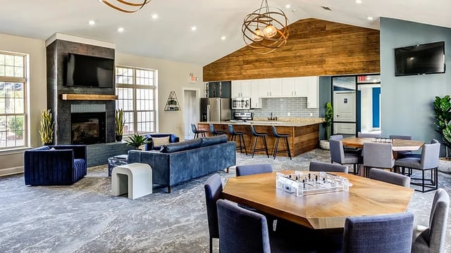 Couches fireplace kitchen bar and dining tables communal area at The Hangout in Starkville Student Accommodation