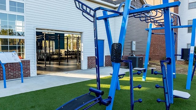 Outdoor exercise equipment on turf with gym exterior. at The Hangout in Starkville Student Accommodation