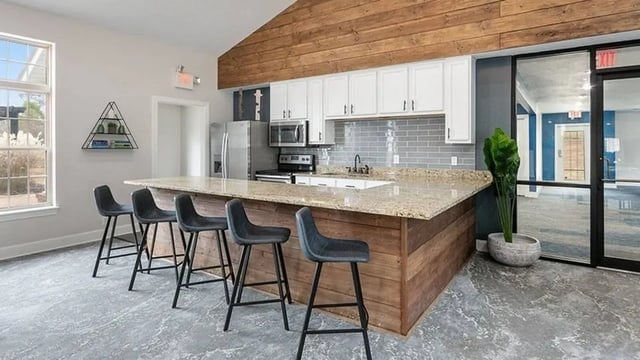 Island bar with stools and kitchen appliances kitchen at The Hangout in Starkville Student Accommodation