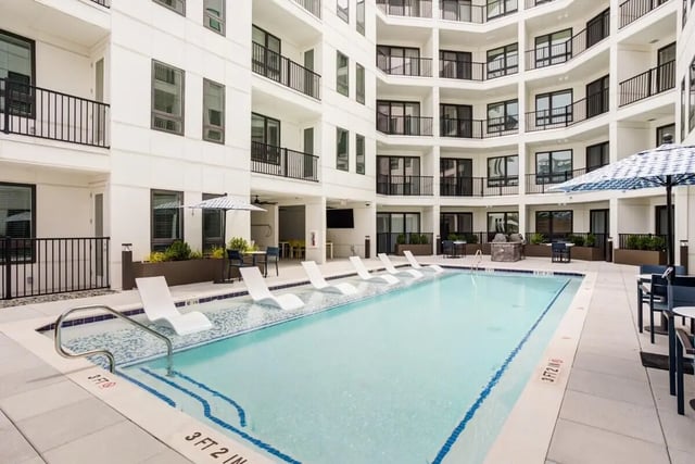 Pool with lounge chairs and umbrellas exterior at Signature Music Row in Nashville Student Accommodation